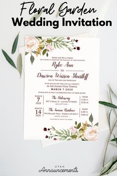 the floral garden wedding invitation is shown with flowers and greenery on top of it