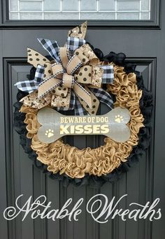 a black and white wreath with a bone on it that says beware of dog kisses