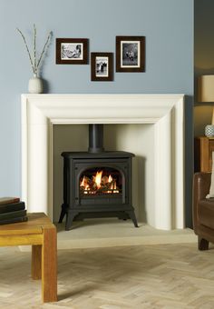 a living room with a fire place and pictures on the wall