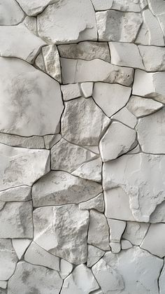 a white stone wall with cracks in it