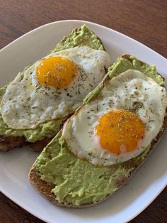 two fried eggs are on top of avocado toast