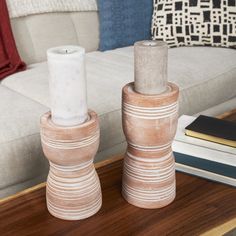 two vases sitting on top of a wooden table next to a white couch in a living room