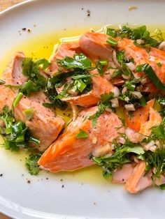 a white plate topped with salmon and greens