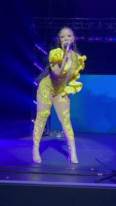 lady in yellow outfit on stage with microphone