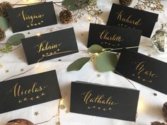 black place cards with gold foil lettering and greenery on the table at a winter wedding