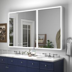 a bathroom with double sinks and large mirrors