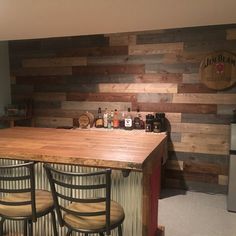 a kitchen with wooden walls and bar stools in front of an island counter top