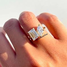 a woman's hand with a diamond ring on top of her finger and an engagement band