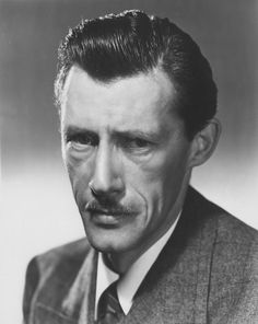 an old black and white photo of a man in a suit with a moustache