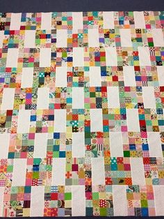 a multicolored patchwork quilt is displayed on a table