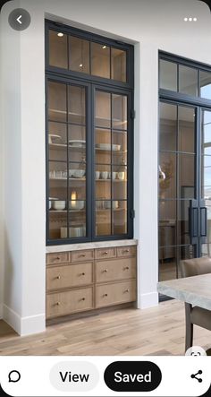 a dining room with glass doors and wooden furniture