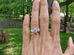 a woman's hand with a ring on it in the middle of her fingers