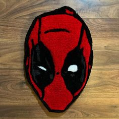 a close up of a deadpool rug on a wooden floor