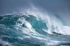 a large wave crashing into the ocean