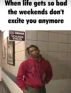 a man in a red hoodie standing next to a wall with a sign that says, when life gets so bad the weekends don't exite you anymore