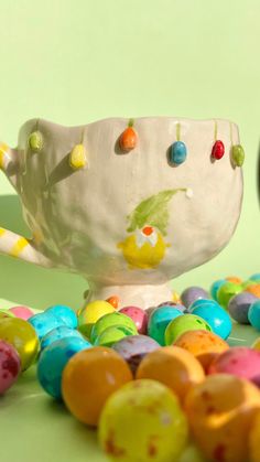 a bowl filled with lots of candy next to some candies on a table top