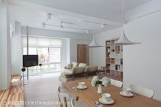 a dining room table with white chairs and plates on it in front of a bookcase