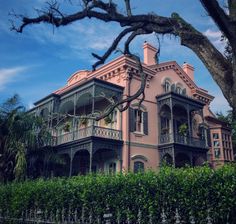 an old pink house with two balconies on the front and second story balcony