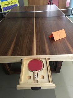 a ping pong table with a card in the middle and an orange piece of paper sticking out of it