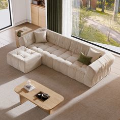 a living room with a large sectional couch and coffee table in front of the window