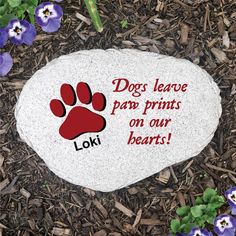 a rock with the words dogs leave paw prints on our hearts