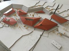 an architectural model is shown with red roofs and gold trimmings on the edges