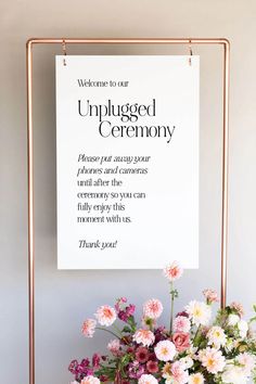 a bouquet of flowers sitting on top of a table next to a sign that reads welcome to the wedding of lauren and bradley