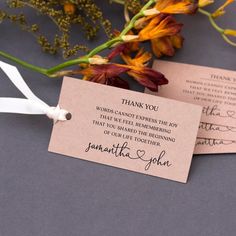 two wedding thank tags with flowers and ribbon tied to the back of each tag, on a gray background