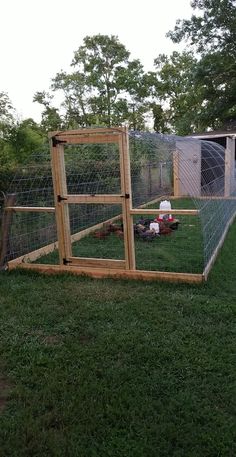 an outdoor chicken coop in the middle of a yard