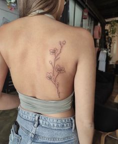 a woman with a flower tattoo on her back