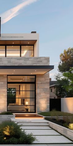 an exterior view of a modern home with stairs leading up to the front door and patio area