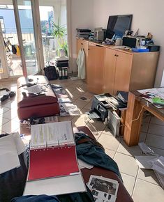 a living room filled with furniture and lots of clutter on top of the floor