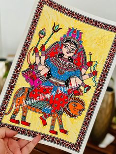 a person holding up a card with an image of a woman riding on a horse