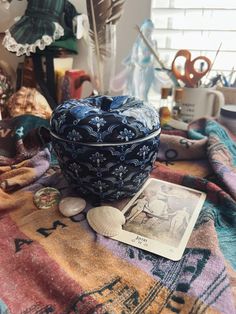 a blue bowl sitting on top of a table next to a book and seashell