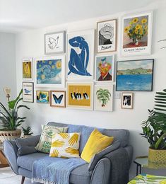 a living room filled with furniture and lots of pictures on the wall above it's couch