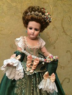 a doll is dressed in a green dress