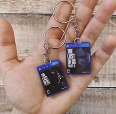 the last of us part ii keychains are being held by someone's hand