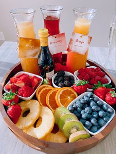 a wooden bowl filled with fruit and drinks