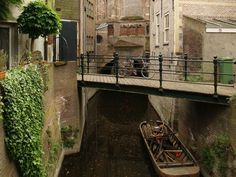 there is a small boat in the narrow canal