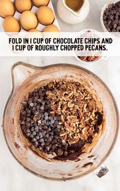 chocolate chips and eggs in a bowl with the words, fold in cup of chocolate chips and i cut up roughly chopped pecans