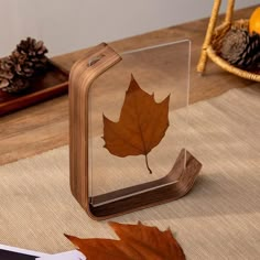 a wooden table topped with a glass block and a leaf on it's side