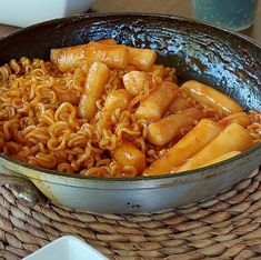 a pan filled with noodles and meat on top of a table