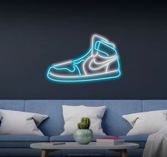 a living room with a blue couch and a neon nike shoe wall decal on the wall