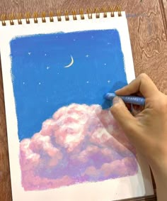 a person is drawing clouds with colored pencils