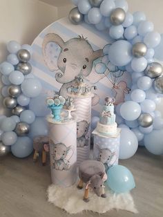 an elephant themed baby shower with blue and silver decorations, balloons, and cake on the floor