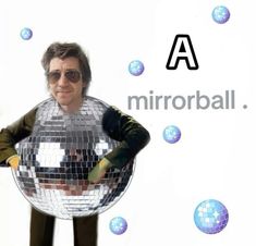 a man standing in front of a mirror ball