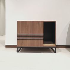 a wooden cabinet sitting on top of a white floor next to a black and brown dresser