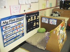 an office cubicle with posters on the wall and stuffed animals sitting in front of it