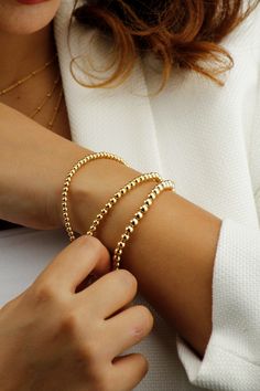 14k Gold Filled Tarnish Resistant Beaded Ball Bracelet.  A Minimalist Gold Bracelet That You Can Wear on Its Own or Layer up. Your Perfect Everyday Companion. If You Are Looking for A Quality Bracelet that Keeps its Shine, this is Ideal For You. Stretch to fit variety of wrist sizes Tarnish Resistant and Hypoallergenic Bracelet. DIMENSIONS Material: 14k Gold Filled Ball Bead Sizes 1) 3mm 2) 4mm 3) 5mm Bracelet Length: Fits comfortably for up to 7.5 Inch Wrist diameter What is 14K Gold Filled? '' Gold Ball Bracelet, Bracelets Dainty, Stacking Bracelets, Gold Armband, Ball Bracelet, Rose Gold Bracelet, Layered Bracelets, Beaded Stretch Bracelet, Bracelet Gold