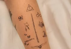 a person with a harry potter tattoo on their arm and leg, holding a wand